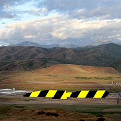 Image of black and yellow roadblock before a desert